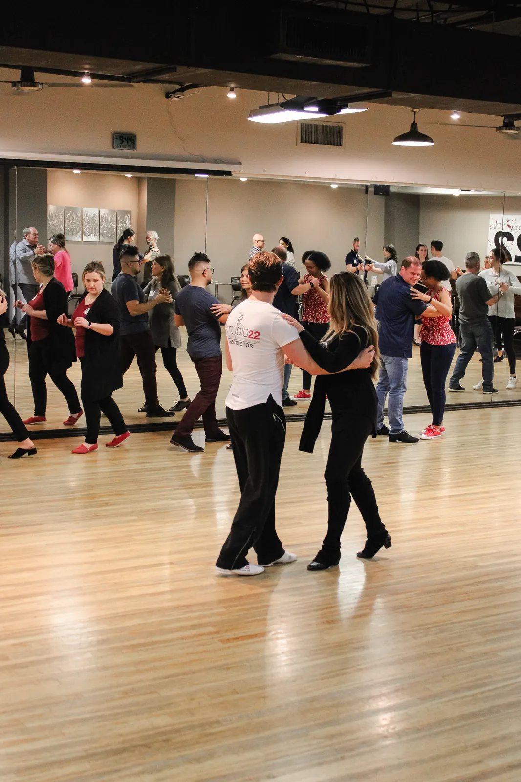 Adult beginners practicing a partner dance step in a group class at Studio 22 Dallas