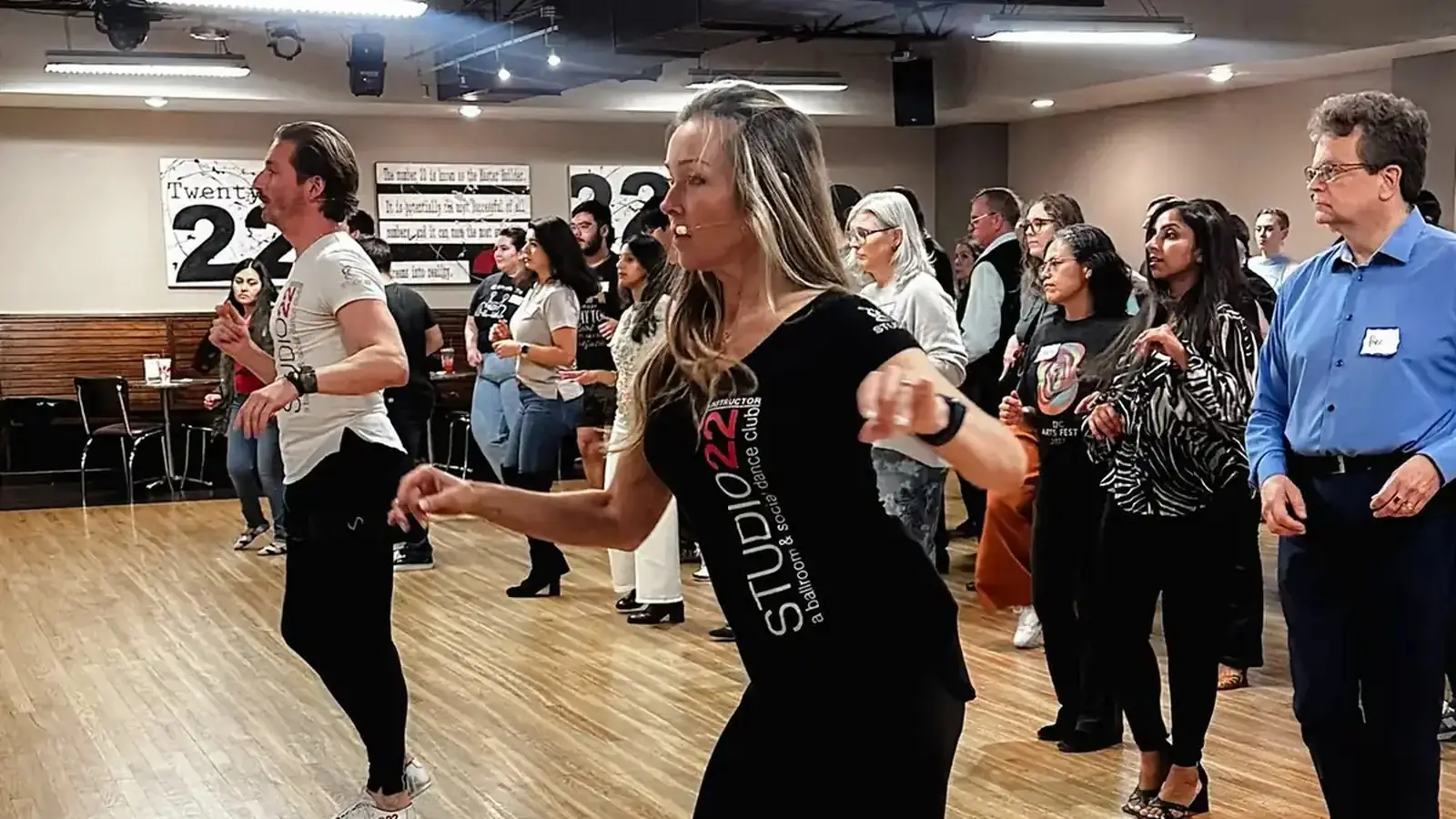 Studio 22 instructor leading salsa for a packed beginner class
